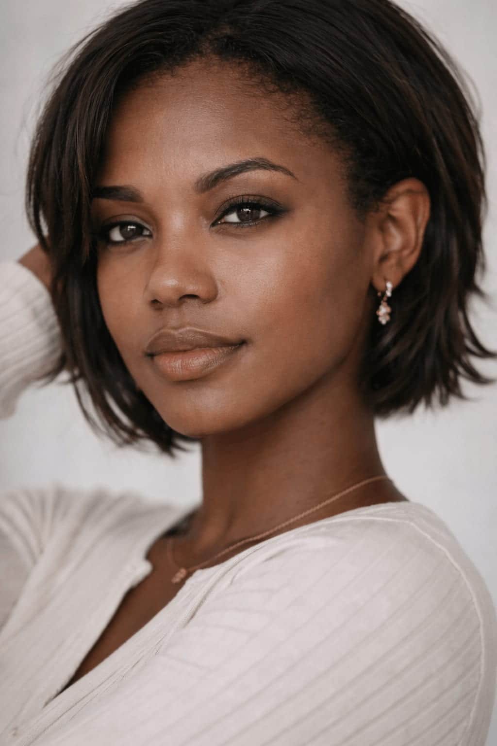 Portrait of a woman with deep brown skin and a short dark bob, her skin clear and even.